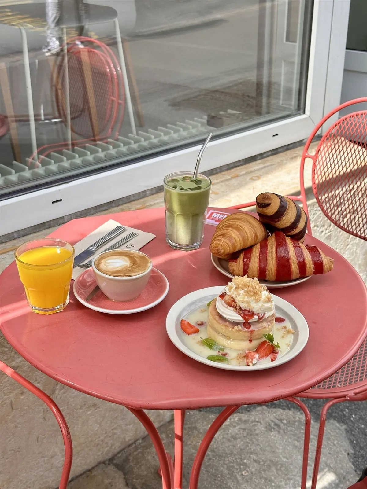 Butter croissants, cappuccino and orange juice on a terrace table