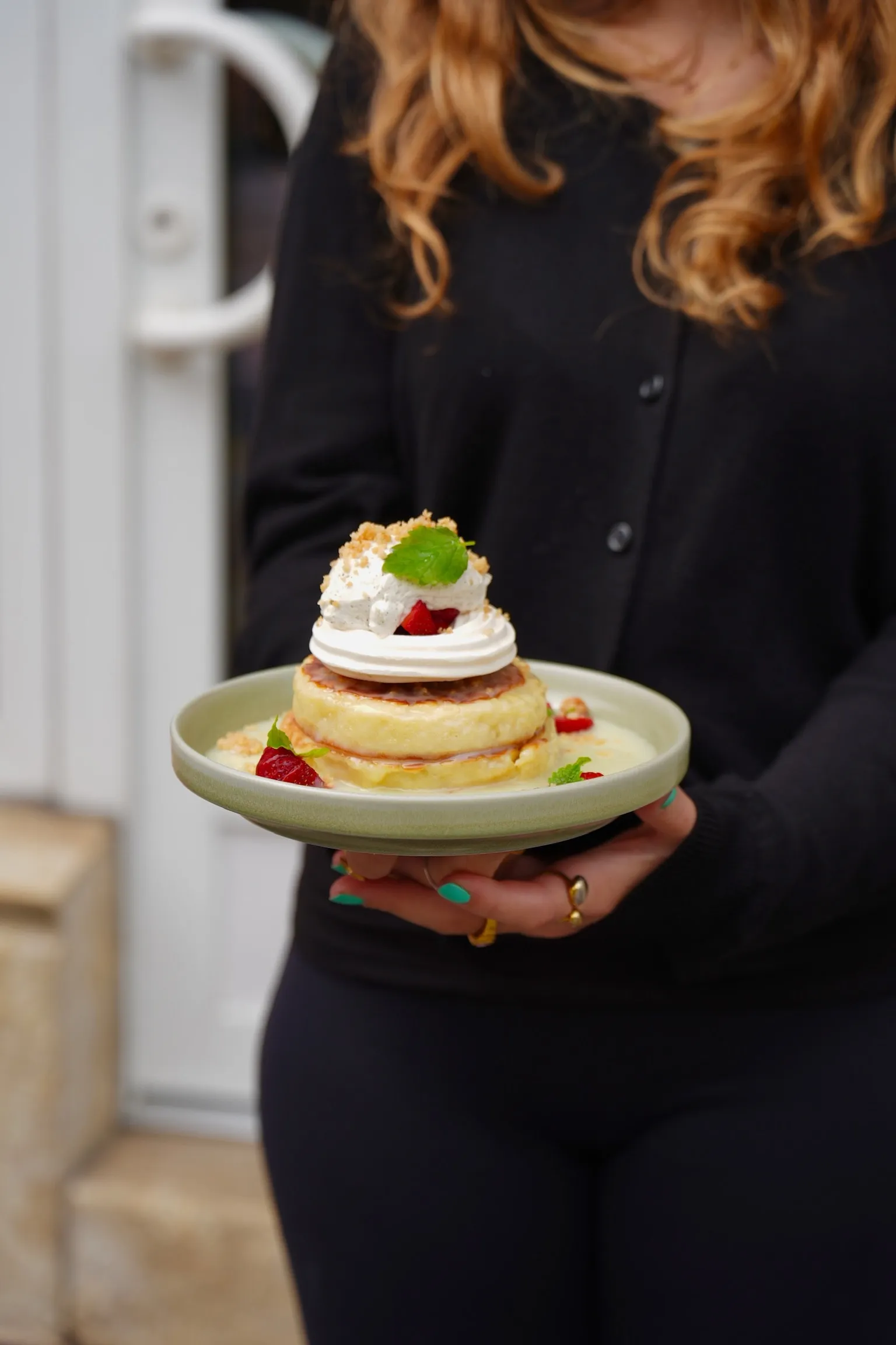 Table service: soufflé pancakes with whipped cream and strawberries.