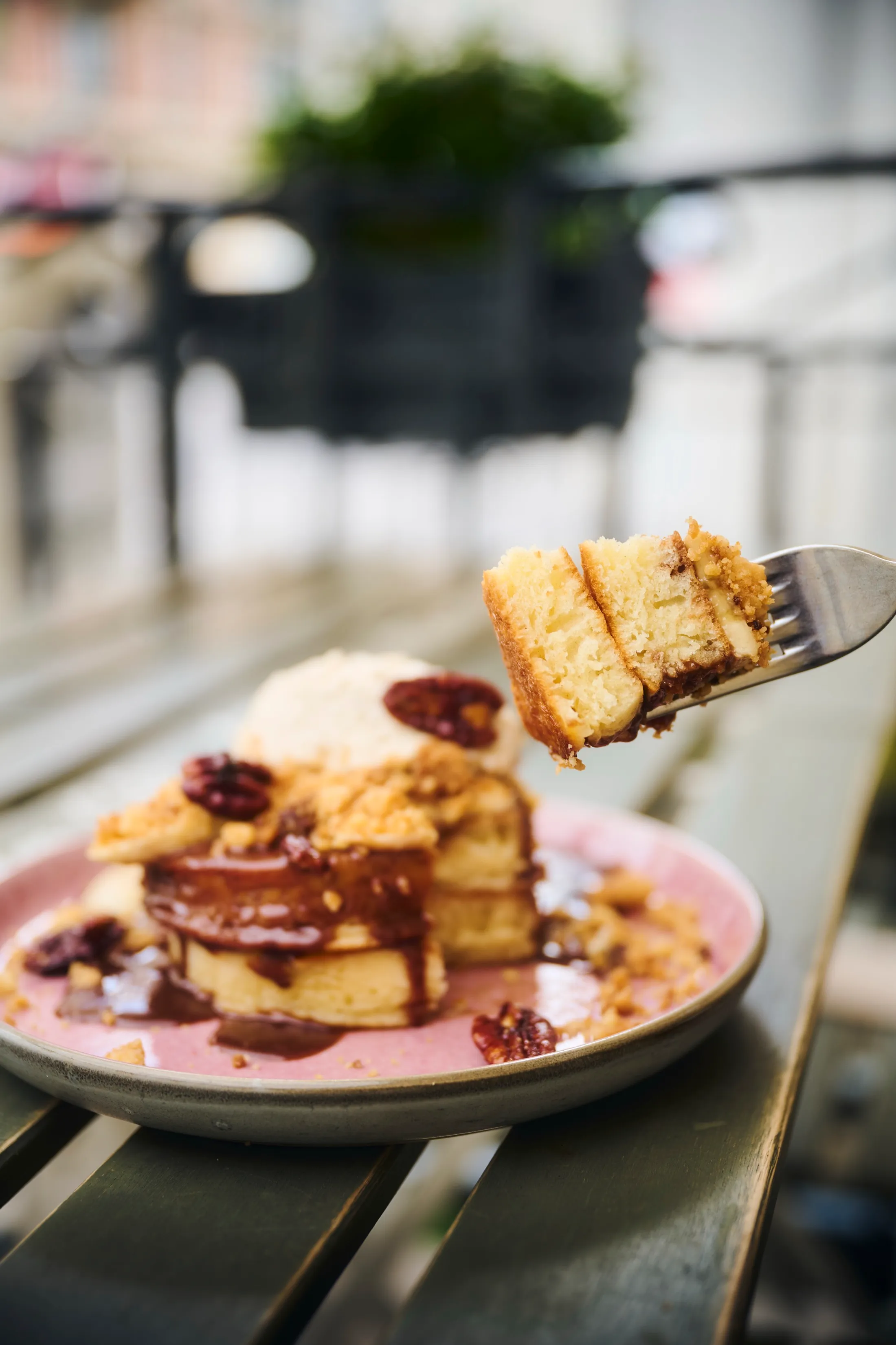 Forkful of pecan-caramel pancakes held up on the terrace