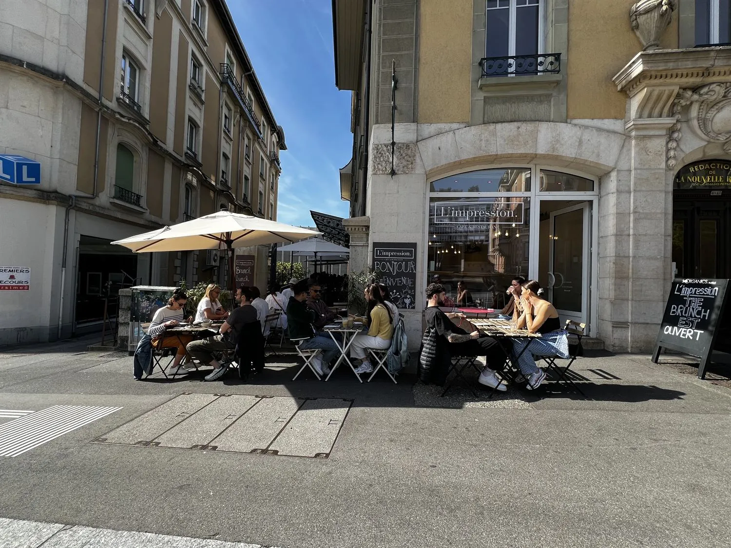 Guests seated on the terrace of L'Impression Café on a summer day